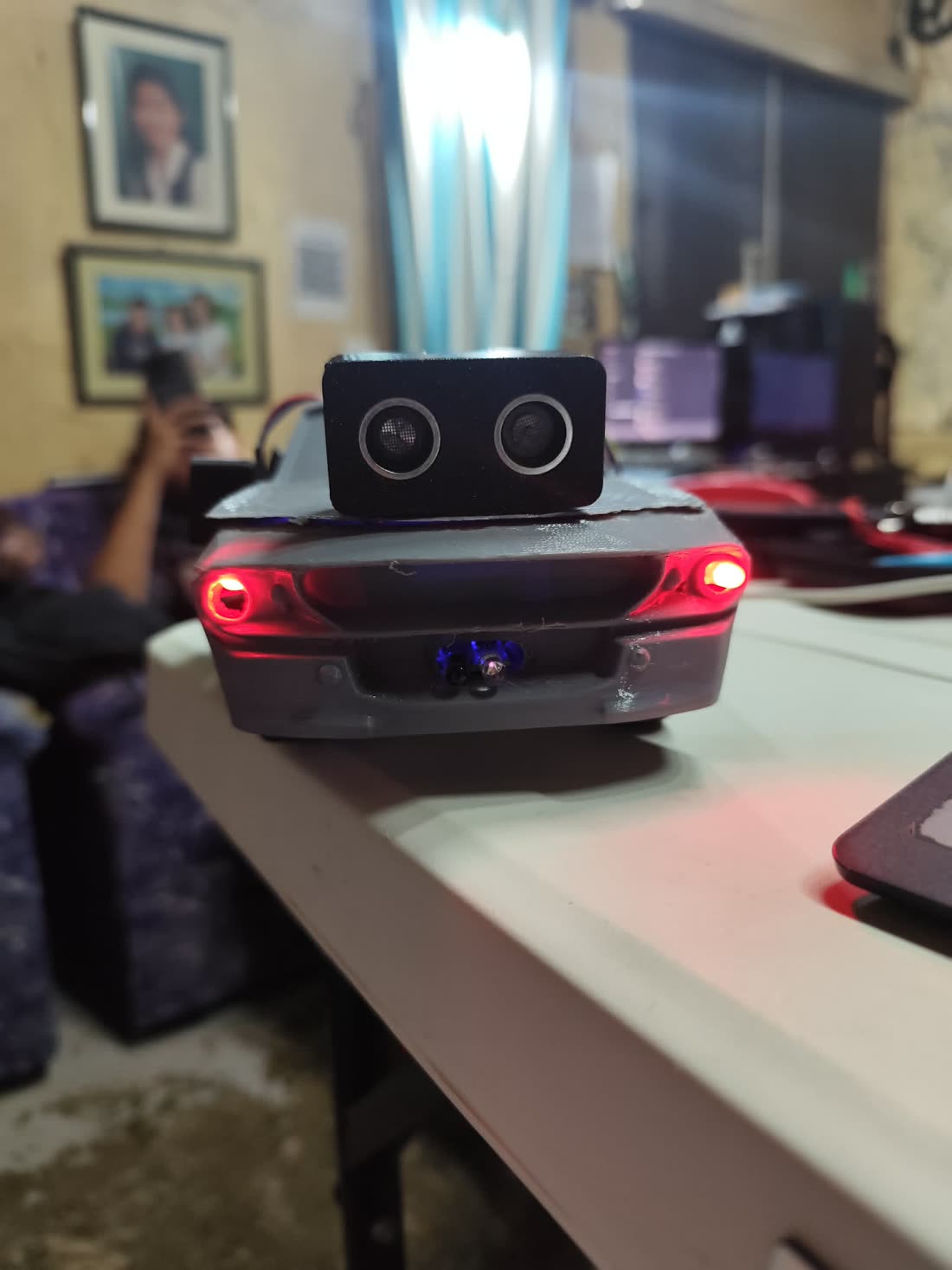 ChaChaBot front view, sonar sensor mounted as twin eyes with red LED headlights lit